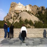 Judy walking to pose in front of Mount Rushmore National Memorial